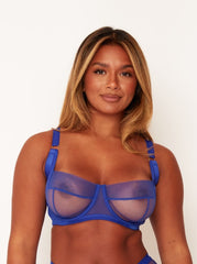 Woman wearing a blue bra against a white background
